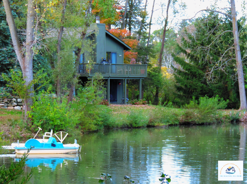 A charming lakefront home in Oakland County, MI, surrounded by lush trees with a private dock and paddle boat. This scenic setting makes it a prime location for waterfront homebuyers in Michigan…