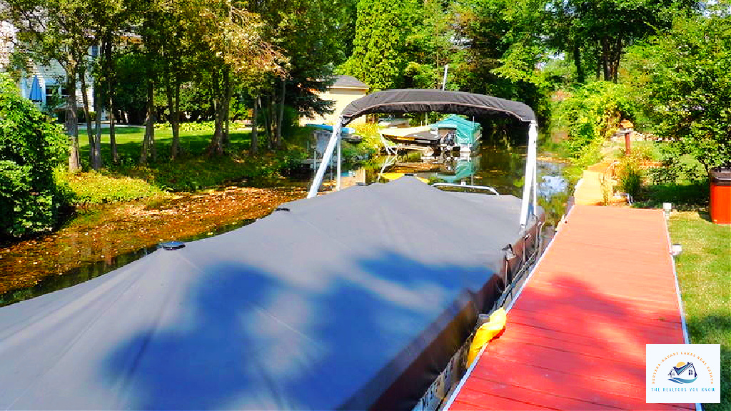 A covered boat dock along a canal in West Bloomfield, MI, offering private access to the water. Waterfront homes in this area provide a perfect blend of convenience and lakefront living, making them highly desirable for Michigan homebuyers…
